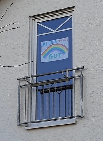 Grafik: Ein Regenbogenbild ist auf ein Fenster der Grundschule geklebt.