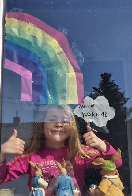 Grafik: Regenbogenbild an einem Fenster. Man sieht auch noch ein Kind, das beide Daumen nach oben zeigt.