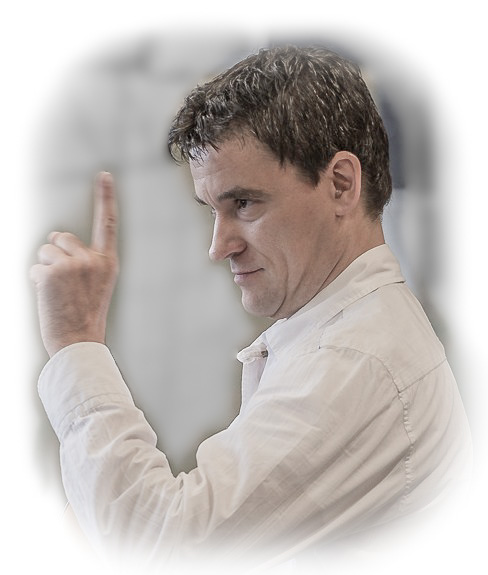 Foto von Herrn HÃ¶hler in der typischen Lehrer-Lempel Pose mit gehobendem Zeigefinger. 